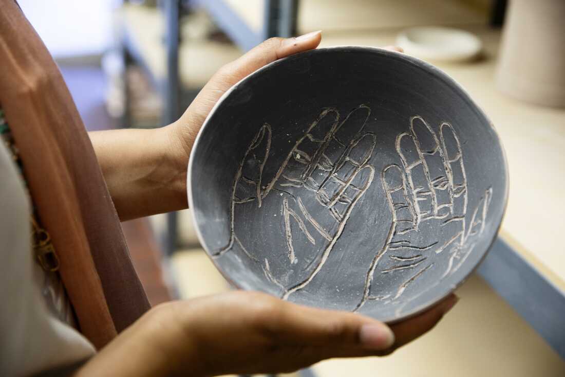 Sellars displays a bowl she made in the ceramics studio at the IMAN building in Chicago, Illinois.