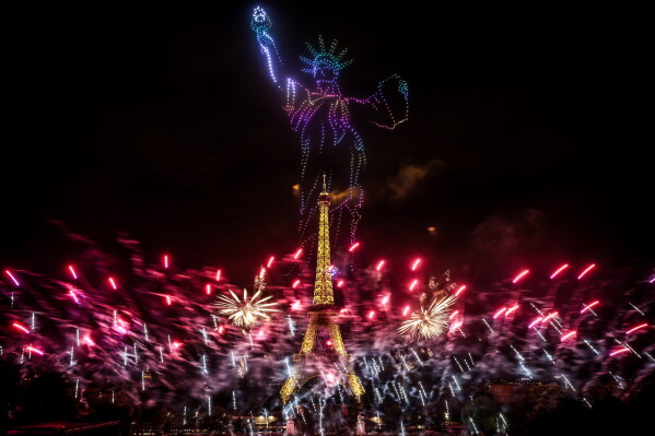Fireworks and drones illuminate the Eiffel Tower in Paris, during the eve of Bastille Day celebrations late Monday, July 13, 2026. (AP Photo/Thomas Padilla)