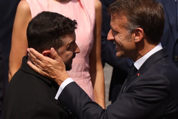 French President Emmanuel Macron, right, speaks with Ukraine's President Volodymyr Zelensky after the Bastille Day military parade on the Champs-Elysees avenue, in Paris, Tuesday, July 14, 2026. (AP Photo/Thomas Padilla)