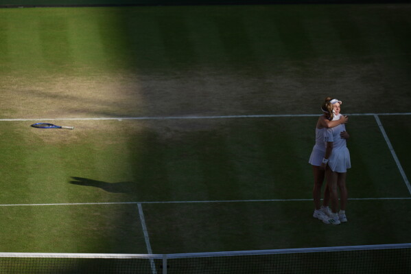 Linda Noskova of Czech Republic right, is embraced by Karolina Muchova of Czech Republic, after she won the women's singles final at Wimbledon Tennis Championships in London, Saturday, July 11, 2026. (AP Photo/Brian Inganga)