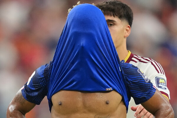 France's Desire Doue covers his face after his side's lost against Spain at the end of their World Cup semifinal soccer match in Arlington, Texas, near Dallas, Tuesday, July 14, 2026. (AP Photo/Julio Cortez)