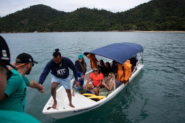 Fisherman Reinaldo Dias da Rocha boards a boat used by a shark protection project at Ilha Grande Bay, Angra dos Reis, Rio de Janeiro state, Brazil, July 14, 2026. (AP Photo/Bruna Prado)