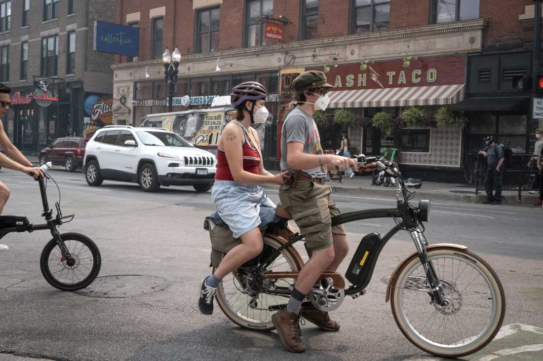 People wear masks in Chicago on Thursday to protect themselves from smoke from Canadian wildfires. City officials are encouraging people to remain inside as data shows Chicago having some of the worst air quality of any large city in the world.