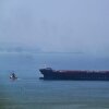 A tugboat guides a ship at the Khor Fakkan Container Terminal.