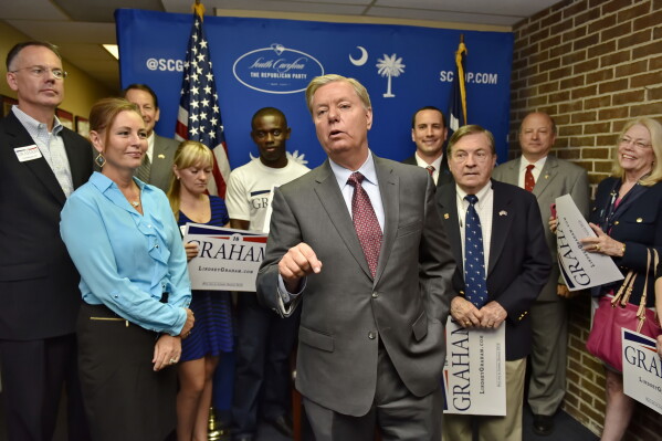 Republican presidential candidate, Sen. Lindsey Graham, R-S.C., accompanied by his sister Darline, left, speaks at the GOP headquarters in Columbia, S.C., Sept. 1, 2015, where he filed for the South Carolina Presidential Primary. (AP Photo/Richard Shiro, File)