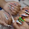 CeeCee Barrett, left, and Vina Nails owner Vy Nguyen, right, showcase their FIFA World Cup-inspired art at her salon in Houston, Texas, on June 26, 2026.
