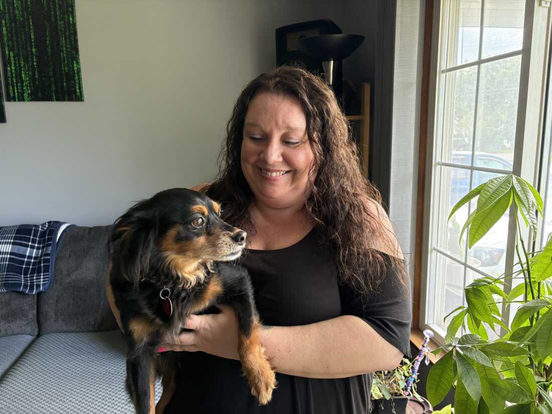 Marie Noon at her home in Brighton, Michigan, with her dog, Ziggy. Despite being eligible for Medicaid, Marie was denied coverage in 2025 because of an error with the state’s benefits system. It took months of pushback before the state reversed its mistake. Even as a “tech-savvy” former bank manager, Marie says, she wanted to give up several times along the way.