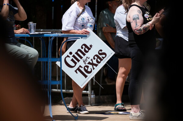 A supporter holds a sign for Democratic candidate for Texas governor Gina Hinojosa while she speaks during a rally, Saturday, July 18, 2026, in Lubbock, Texas. (AP Photo/Justin Rex)