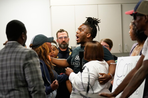 Residents react during a press conference regarding the incident where a man was shot and killed on Wednesday by Madison police, Thursday, July 23, 2026, at the police station in Madison, Wis. (AP Photo/Kayla Wolf)