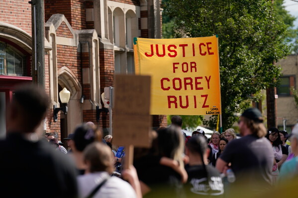 People gather near the site where a man was shot and killed on Wednesday by Madison police, Thursday, July 23, 2026, in Madison, Wis. (AP Photo/Kayla Wolf)