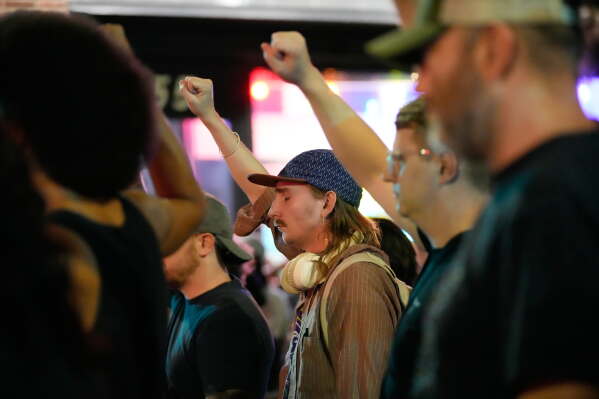 Attendees gesture during a candlelight vigil where a Madison police officer shot and killed a man Wednesday, July 22, 2026, in Madison, Wis. (AP Photo/Kayla Wolf)