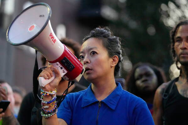 Gubernatorial candidate Francesca Hong speaks alongside protesters near where a Madison police officer shot and killed a man Wednesday, July 22, 2026, in Madison, Wis. (AP Photo/Kayla Wolf)