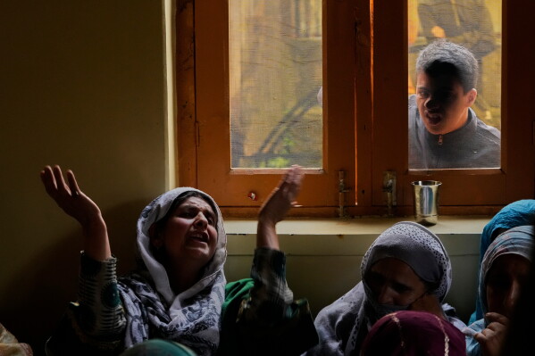 A family member of slain police officer Ashiq Hussain wails inside his home in Lalpora, northwest of Srinagar, Indian-controlled Kashmir, after he was killed in a suspected militant attack in south Kashmir, Wednesday, July 22, 2026. (AP Photo/Mukhtar Khan)