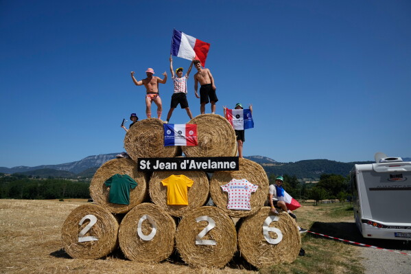 Spectators stand on bales of hay during the seventeenth stage of the Tour de France cycling race, with start in Chambery and finish in Voiron France, Wednesday, July 22, 2026. (AP Photo/Mosa'ab Elshamy)