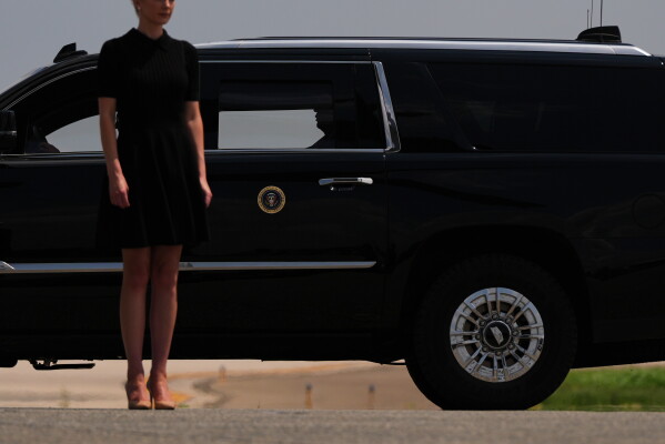 President Donald Trump departs a dignified transfer while White House aide Natalie Harp stands outside the vehicle, Wednesday, July 22, 2026, at Dover Air Force Base, Del. (AP Photo/Julia Demaree Nikhinson)