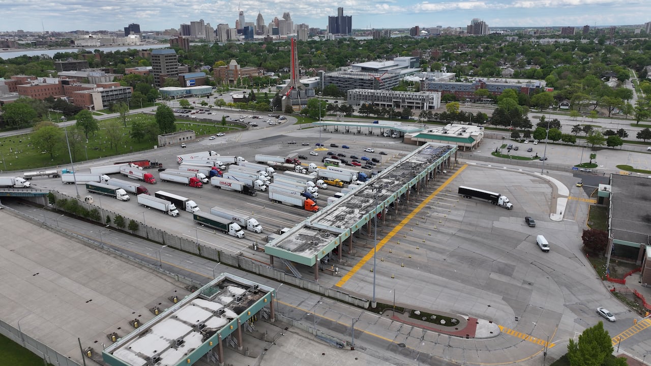 trucks sit in line to cross through a customs terminal in this camera shot from above