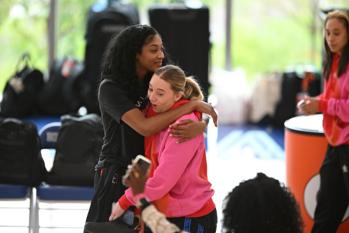 All-Stars Angel Reese, left, and Paige Buekers, right, joke around before practice at the Obama Presidential Center on Friday