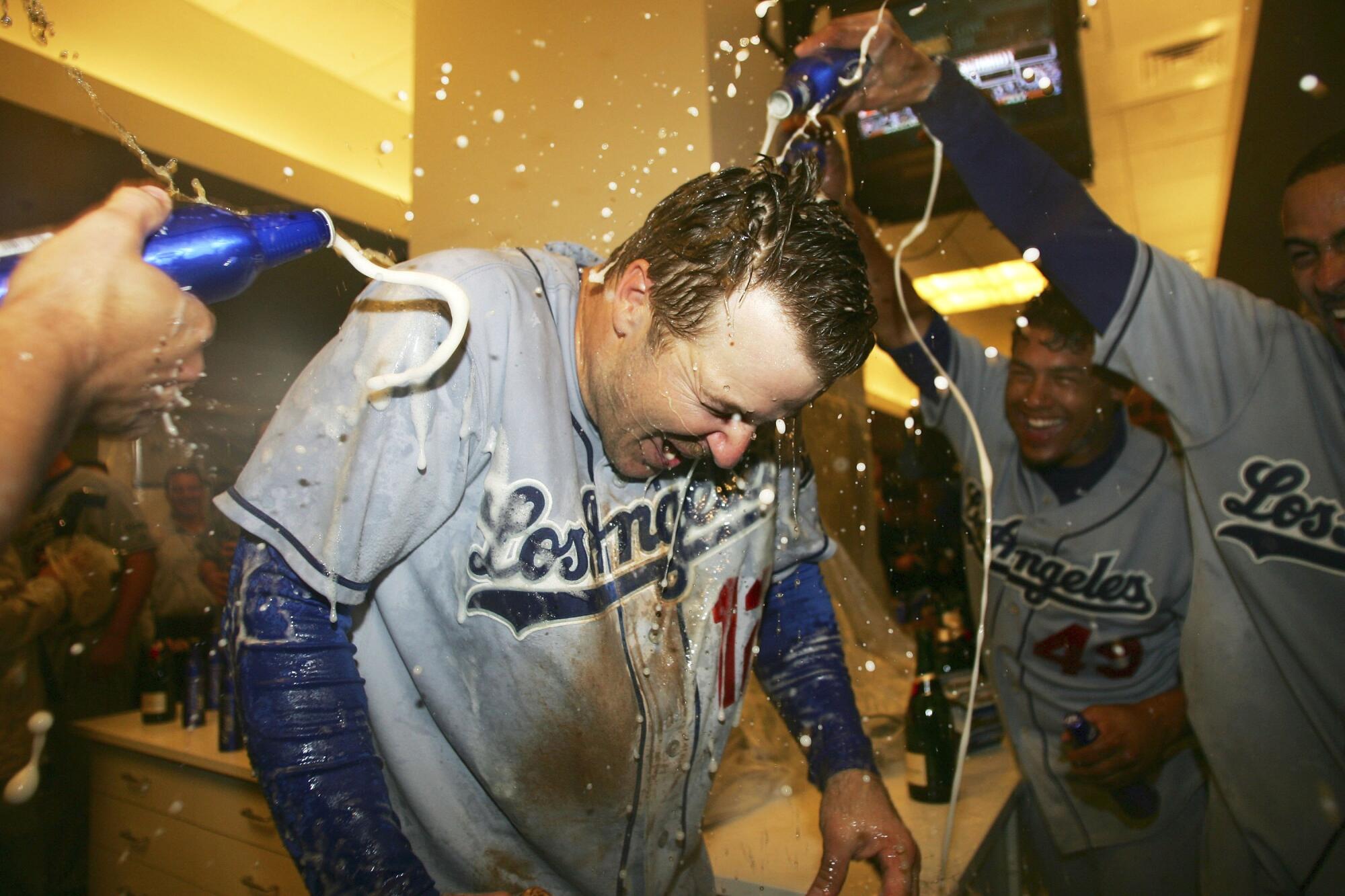 The Dodgers pour beer on teammate Jeff Kent as the team celebrates clinching a playoff spot with a win over the Giants.