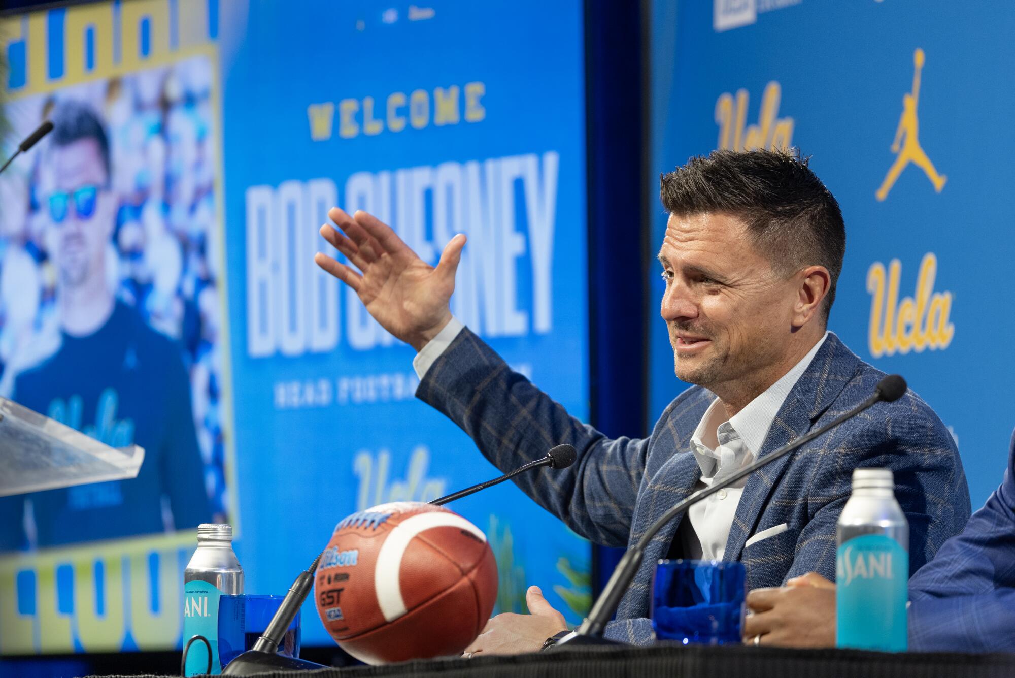 UCLA coach Bob Chesney sits at a table and speaks during a introductory news conference on Dec. 9.