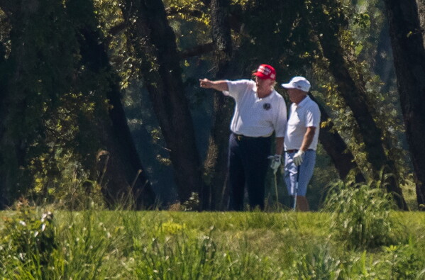 President Donald Trump and Sen. Lindsey Graham, R-S.C., right, play golf at Trump National Golf Club in Sterling, Va., as seen from the other side of the Potomac River in Darnestown, Md., July 18, 2020. (AP Photo/Manuel Balce Ceneta, File)