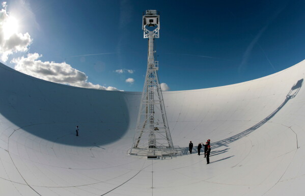 Members of a conference to mark the 50th anniversary of space travel stand in the dish of the The Lovell Telescope at Jodrell Bank Observatory, Macclesfield, England Thursday Oct. 4, 2007. (AP Photo/Jon Super, file)