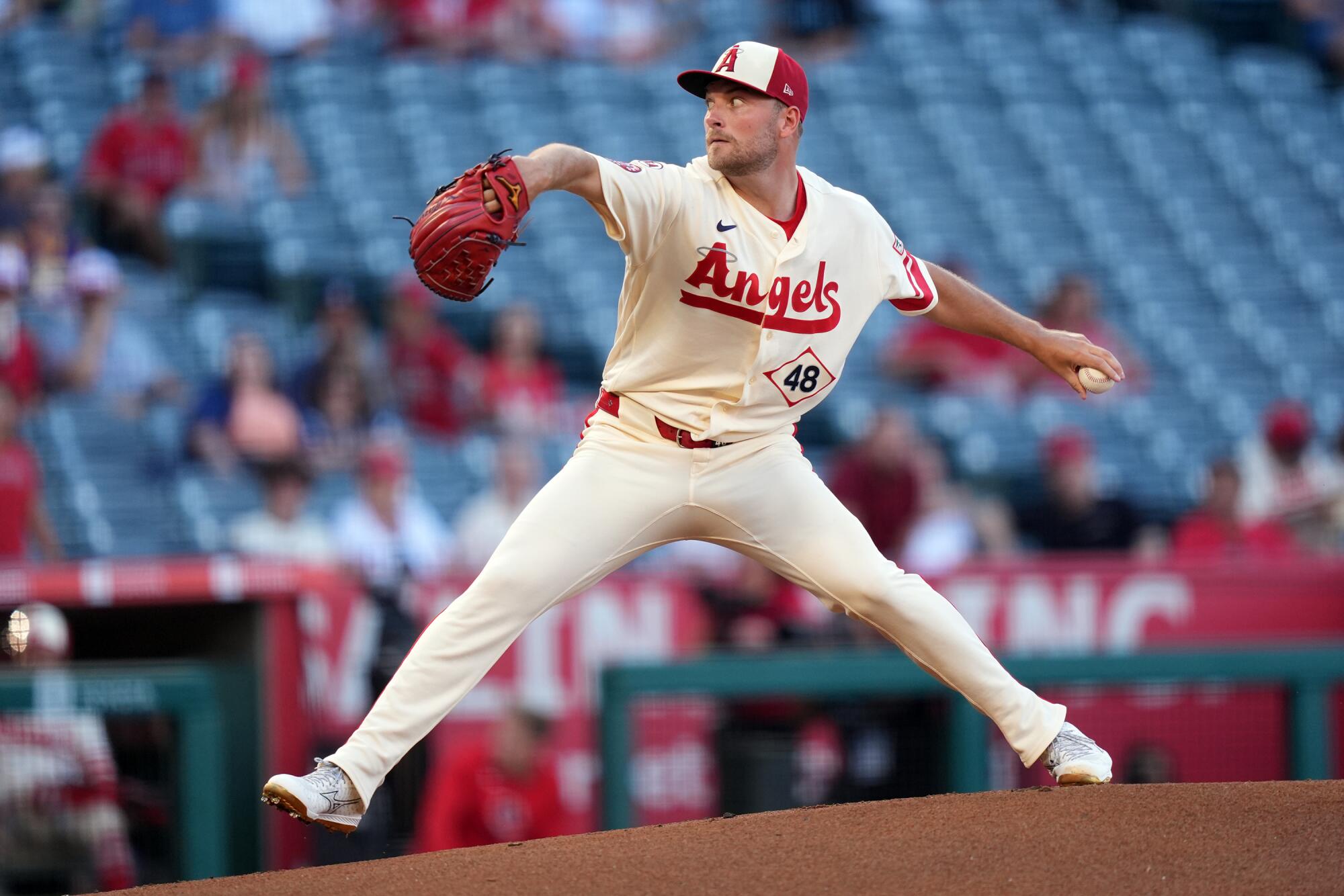 Angels pitcher Reid Detmers throws from the mound against the Houston Astros in front of a sparse crowd.
