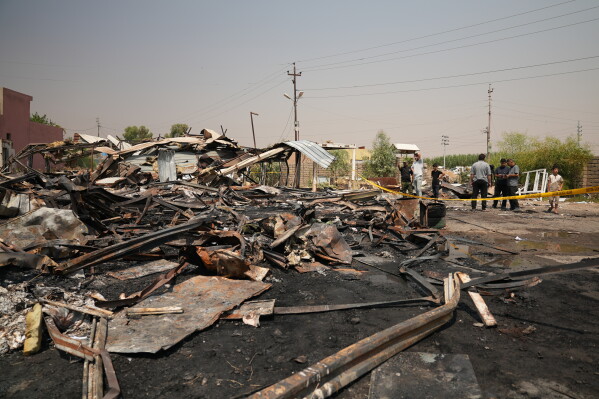 Iraqis inspect damaged structures at the site of an airstrike on a Popular Mobilization Forces base in Mosul, Iraq, Wednesday, July 29, 2026. (AP Photo/Farid Abdulwahed)