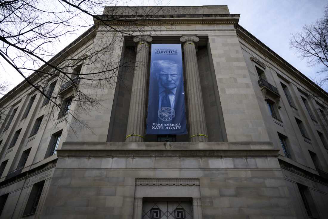 A banner of an image of President Trump is displayed on the facade of the U.S. Department of Justice headquarters in Washington, D.C., in February 2026.