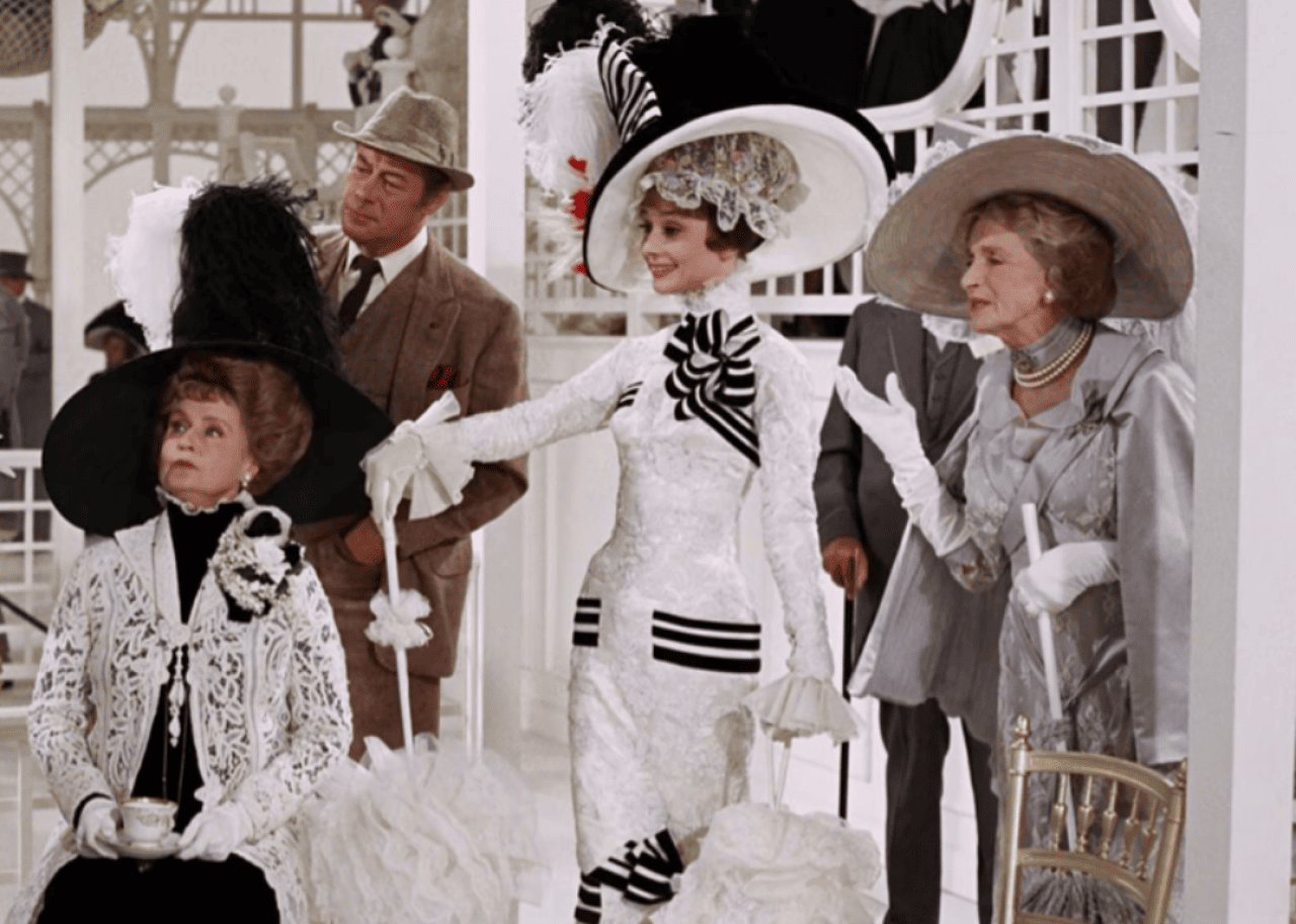 Audrey Hepburn and cast in a scene from ‘My Fair Lady.' -