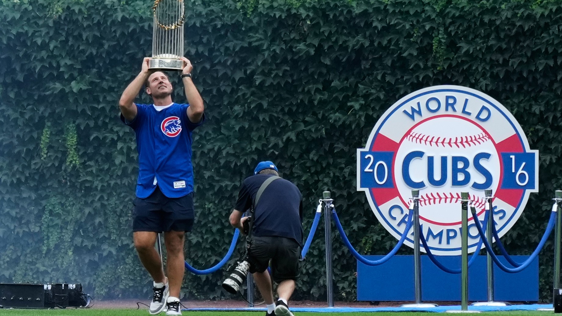 Former Chicago Cubs first baseman Anthony Rizzo holds up the 2016 World Series Championship trophy as his walks on the field before a game in Chicago, Saturday, July 18, 2026.