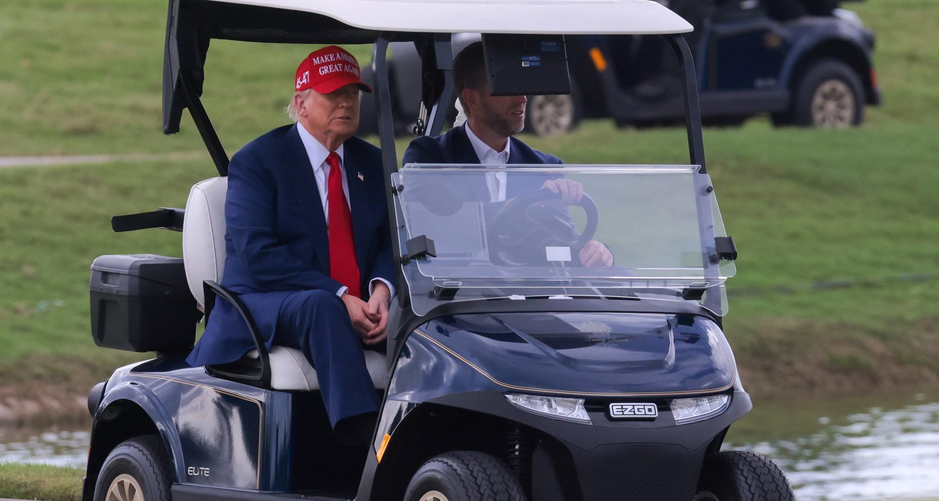Apr 3, 2025; Miami, Florida, USA; President Donald Trump and his son, Eric Trump, drive in a golf cart after he arrived on Marine One at the LIV Golf Miami golf tournament at Trump National Doral.