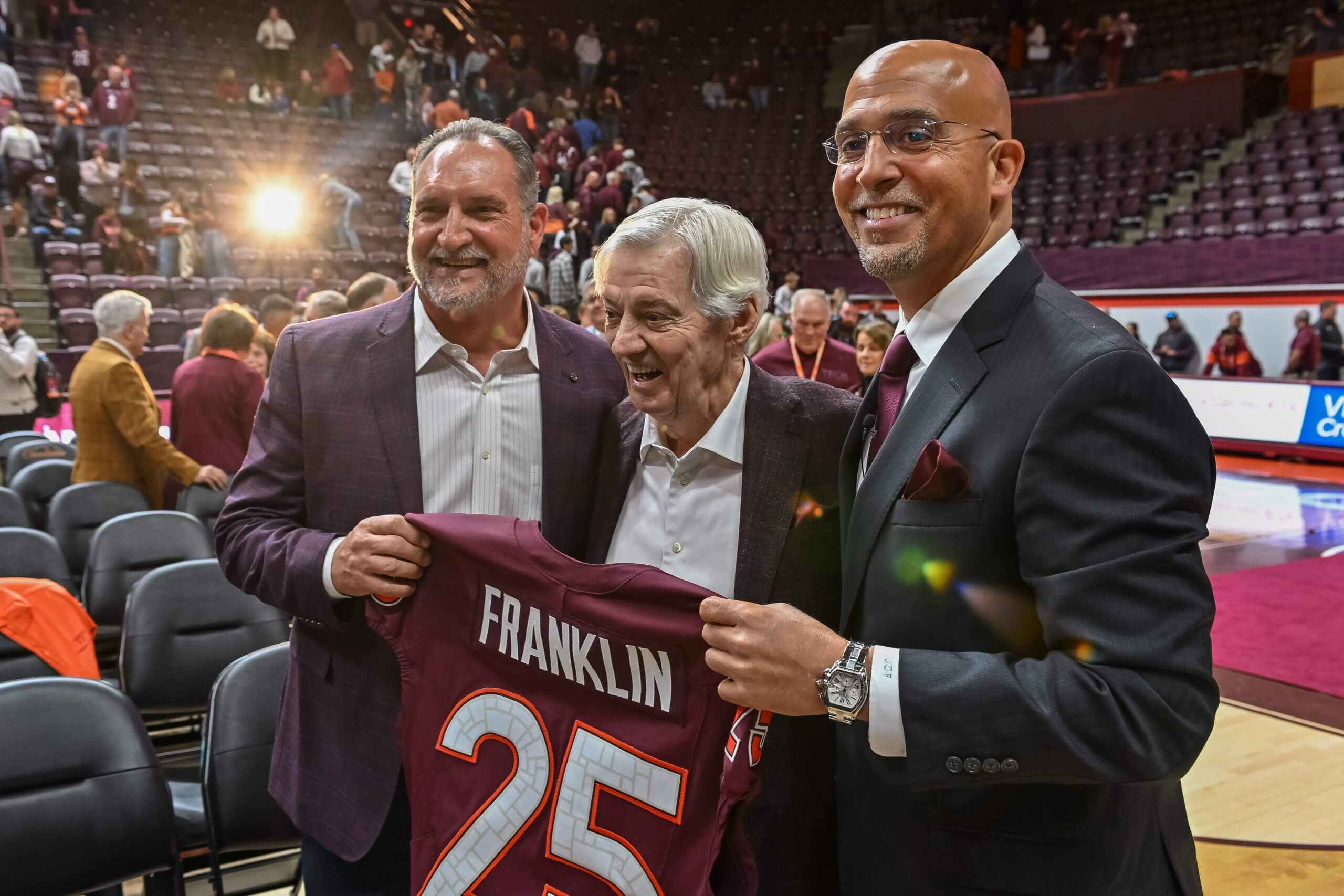 Bud Foster, Frank Beamer and James Franklin stand next to each other and hold a Virginia Tech jersey with Franklin's name on the back