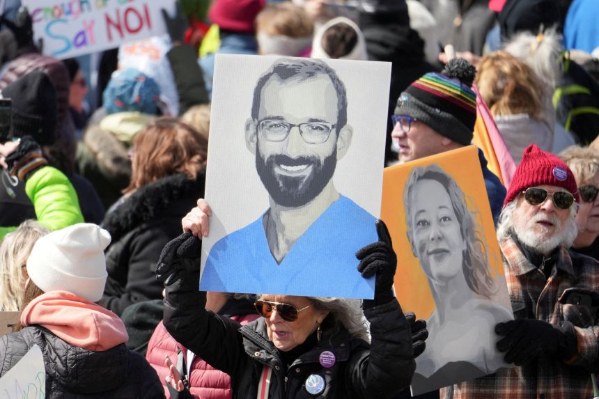 Demonstrators hold images of Alex Pretti and Renee Good during a 