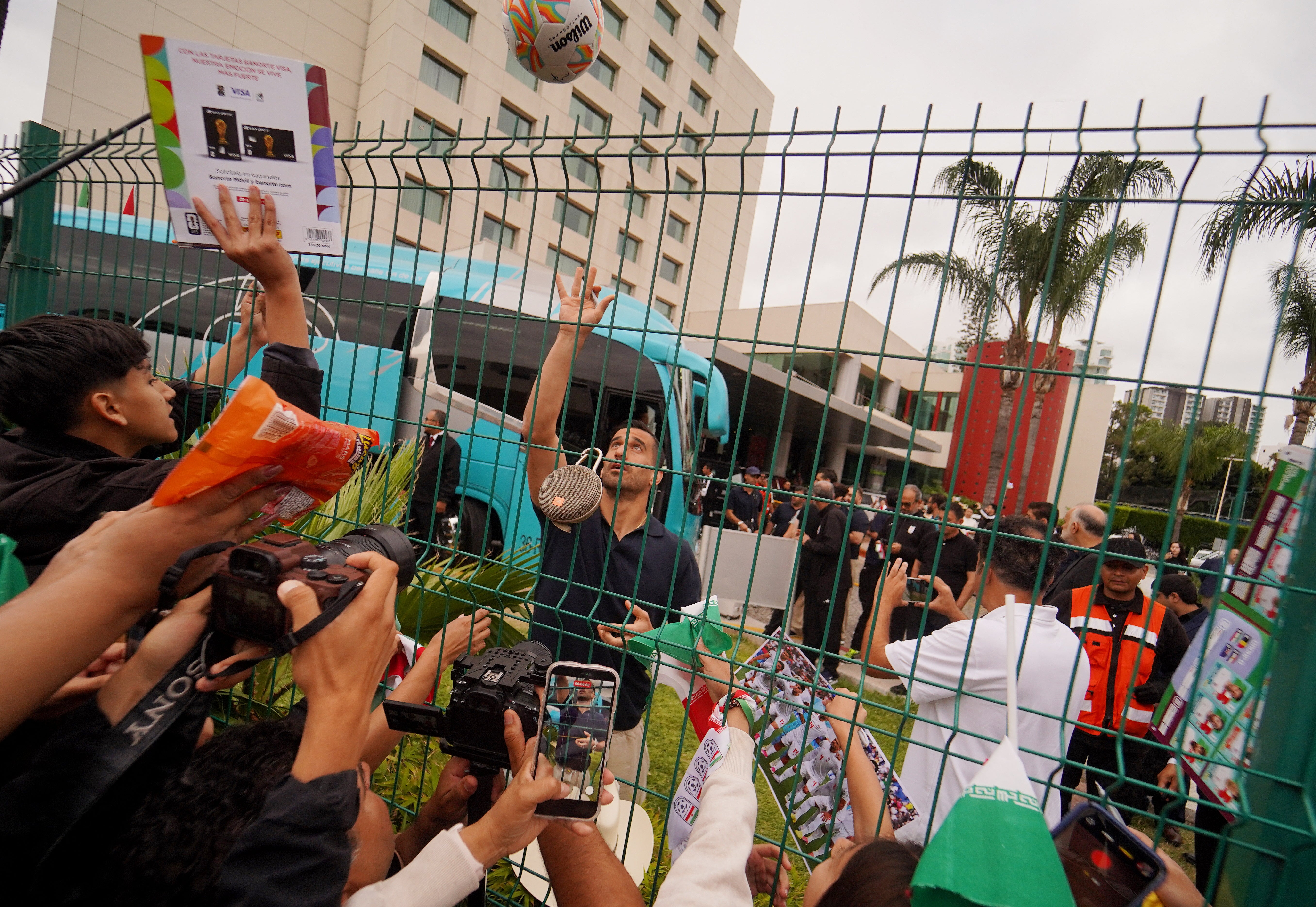 Iran's Ehsan Hajsafi reacts with fans outside the team hotel