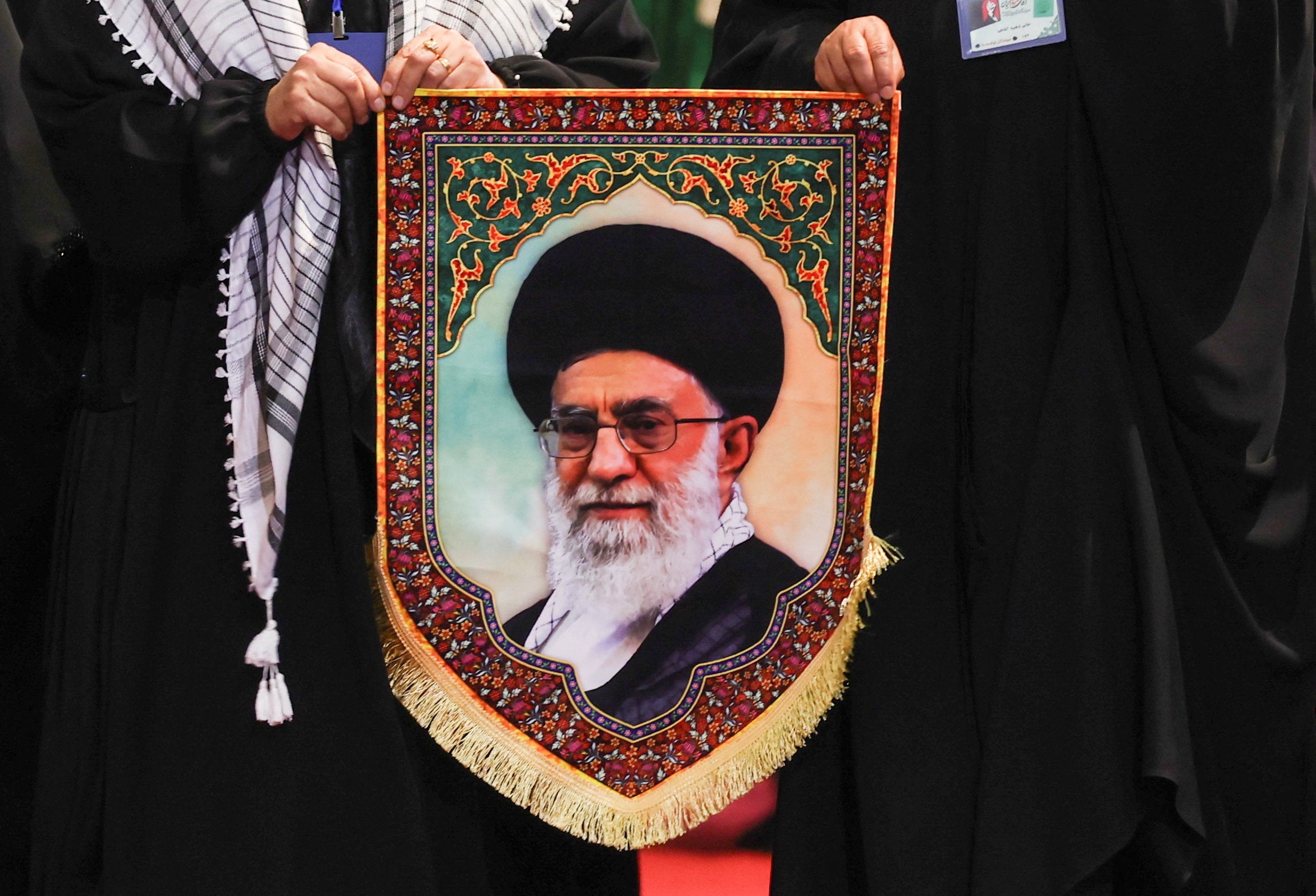 Women hold an image of Iran's late Supreme Leader Ayatollah Ali Khamenei