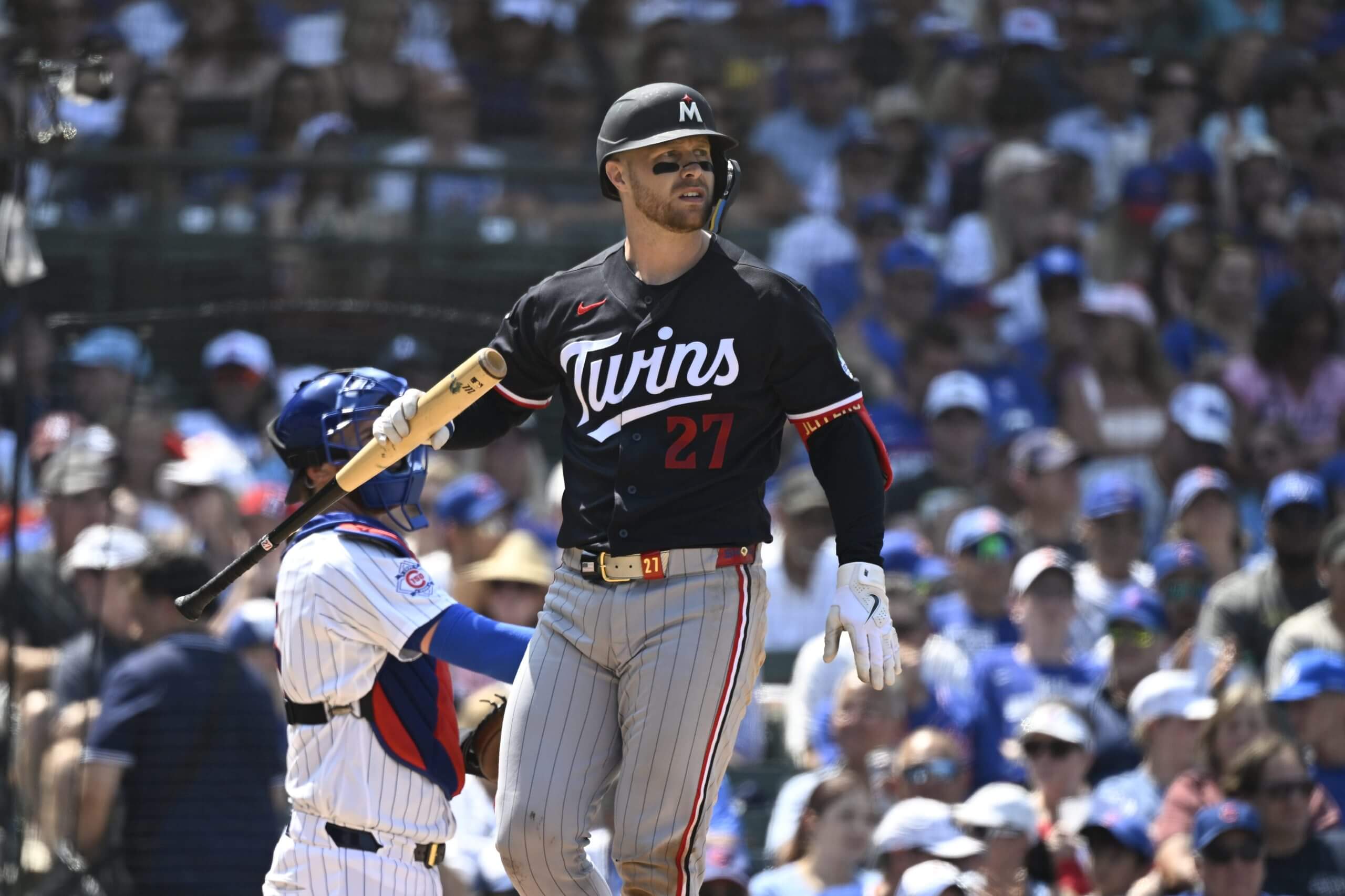 Minnesota Twins catcher Ryan Jeffers holds his bat by the barrel in his right hand and walks away from home plate after striking out in an MLB game against the Chicago Cubs.