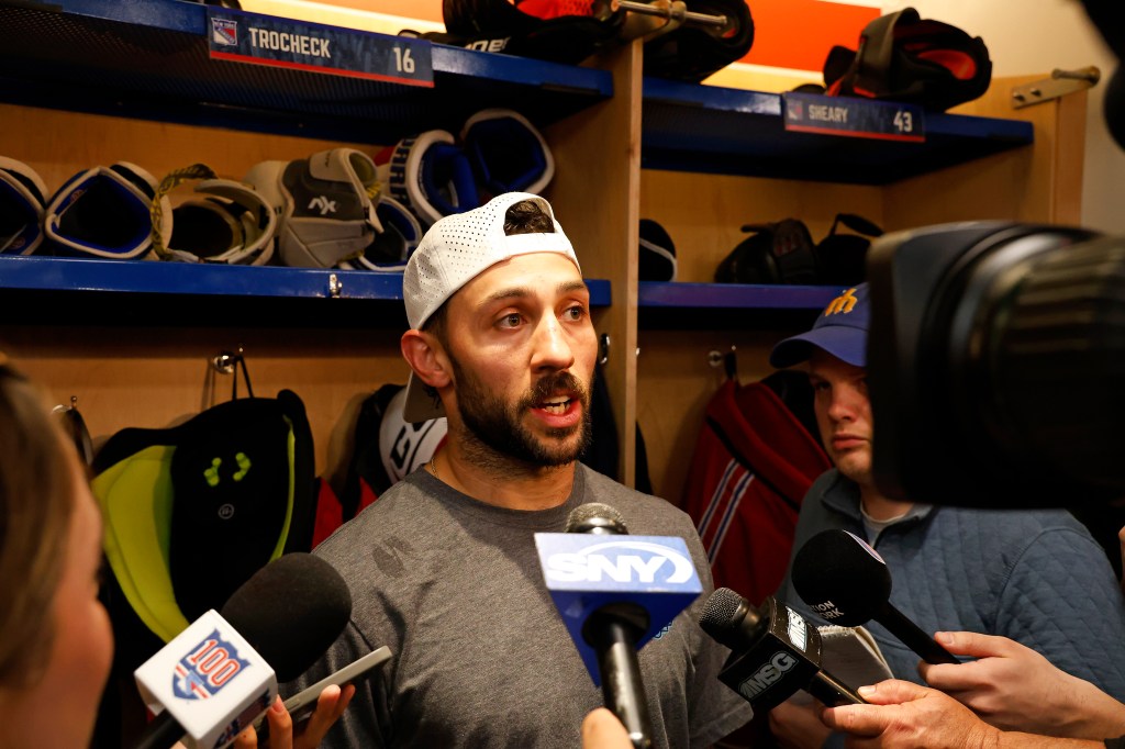 Hockey player Vincent Trocheck giving an interview in a locker room.