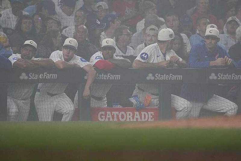 Chicago Cubs stand in the dugout during a fog delay during the sixth inning of a baseball game against the St. Louis Cardinals, Saturday, July 4, 2026, in Chicago. (AP Photo/David Banks)