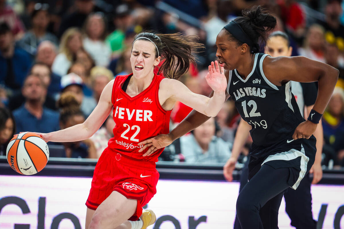 Indiana Fever guard Caitlin Clark (22) tries to fend off Aces guard Chelsea Gray (12) during a ...