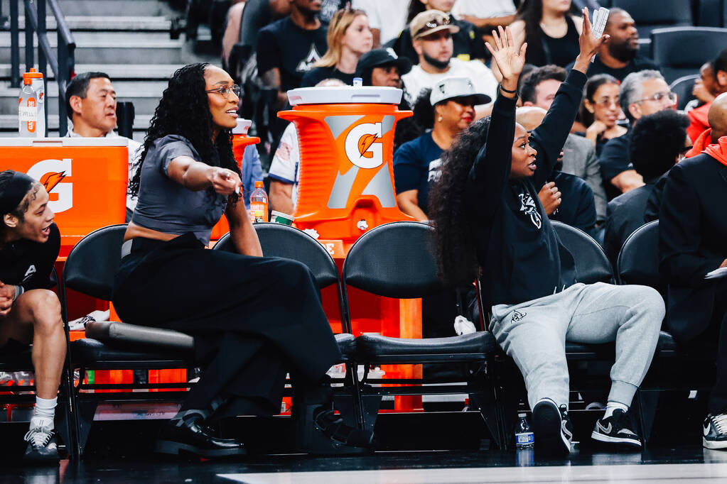 Aces center A'ja Wilson and teammate Dana Evans point to the Aces’ side of the cour ...