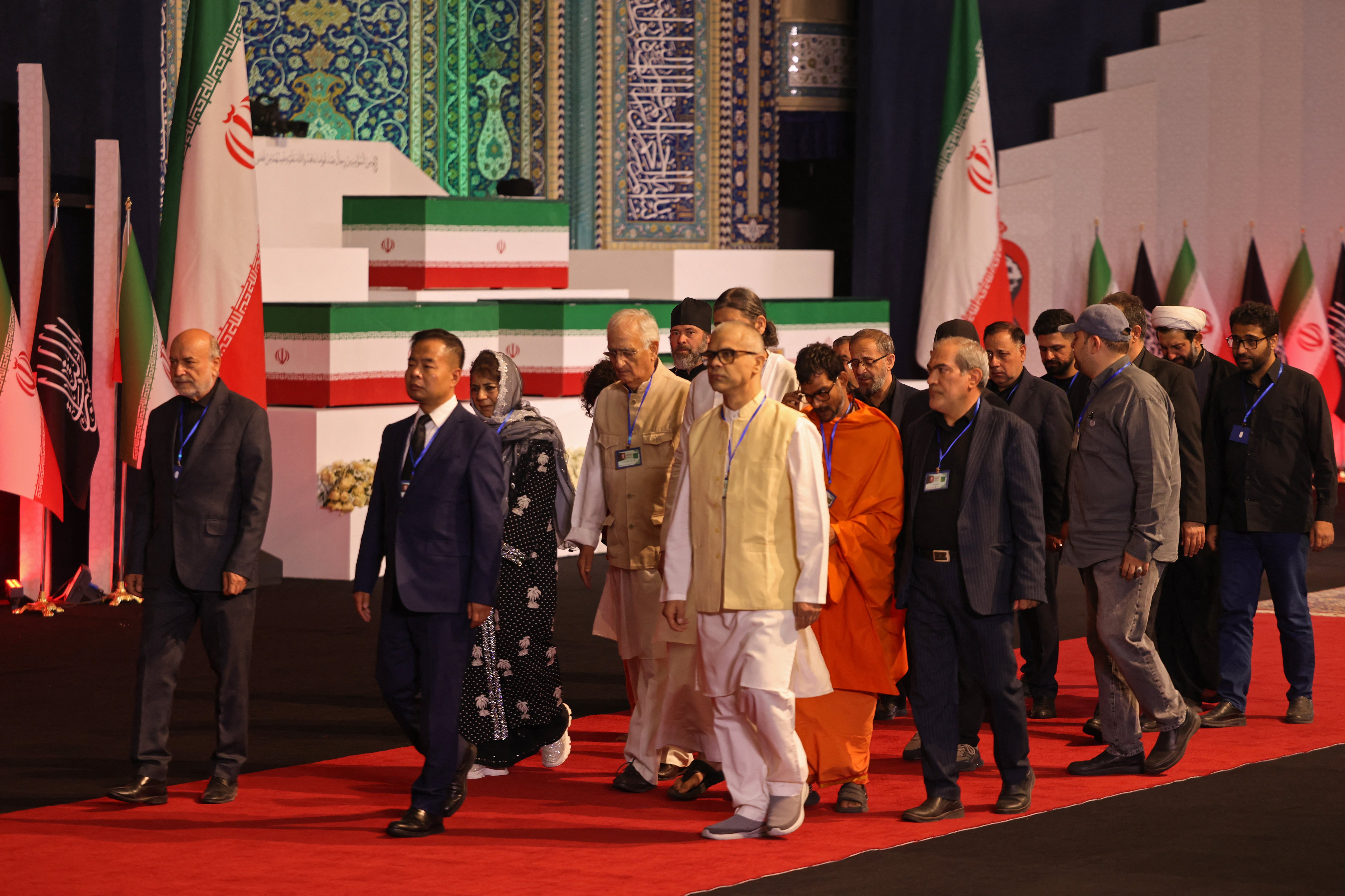 Members of Indian delegation walk past the coffins of Iran's slain supreme leader Ali Khamenei and his family members after paying their respects at the Grand Mosalla in Tehran