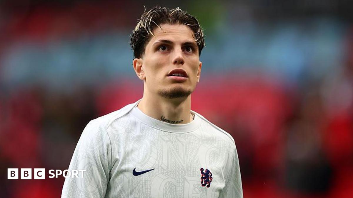 Garnacho looking up into the stands while walking out at Wembley Stadium in Chelsea's training kit
