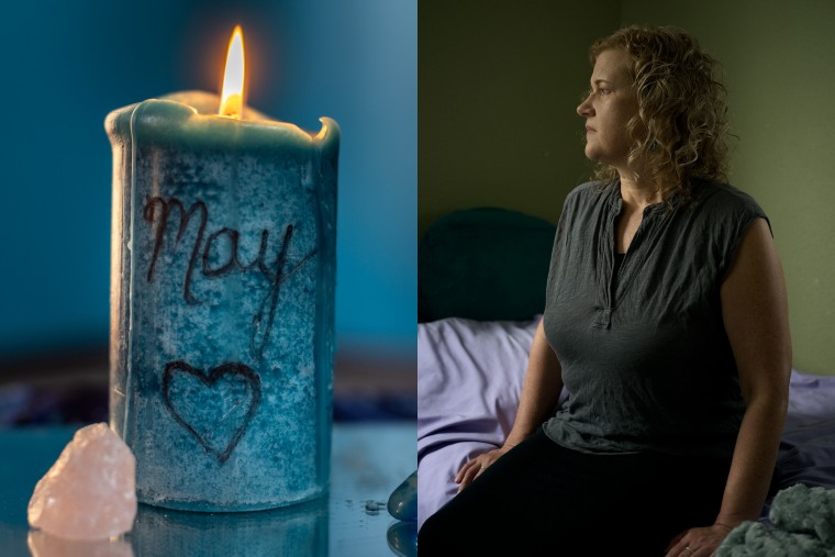 A memorial candle engraved with May's name and a heart; Elyse Thorpe sits on May's bed.