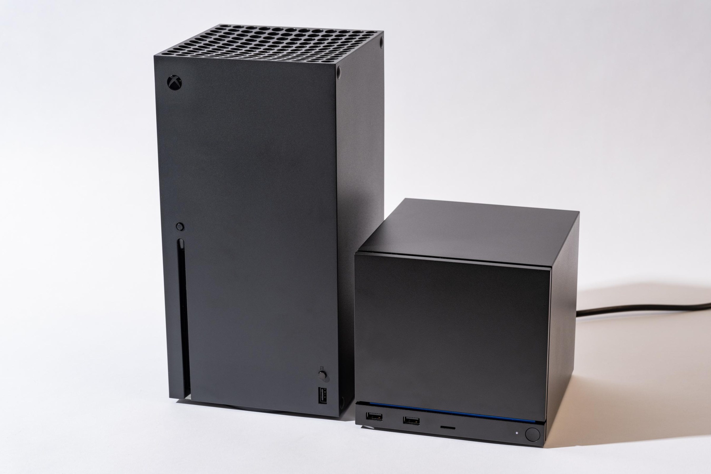 An Xbox Series X next to a Steam Machine. The Steam Machine is roughly half the size of the Series X.