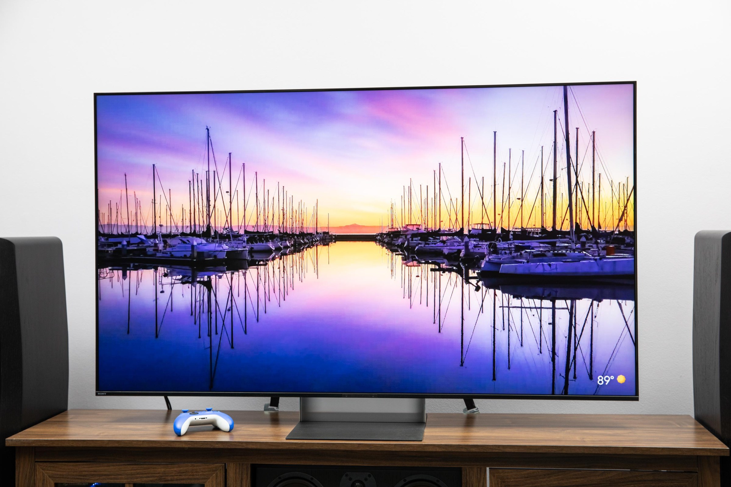 The Sony Bravia 9 II RGB LED TV on a wooden credenza with SVS speakers on either side.