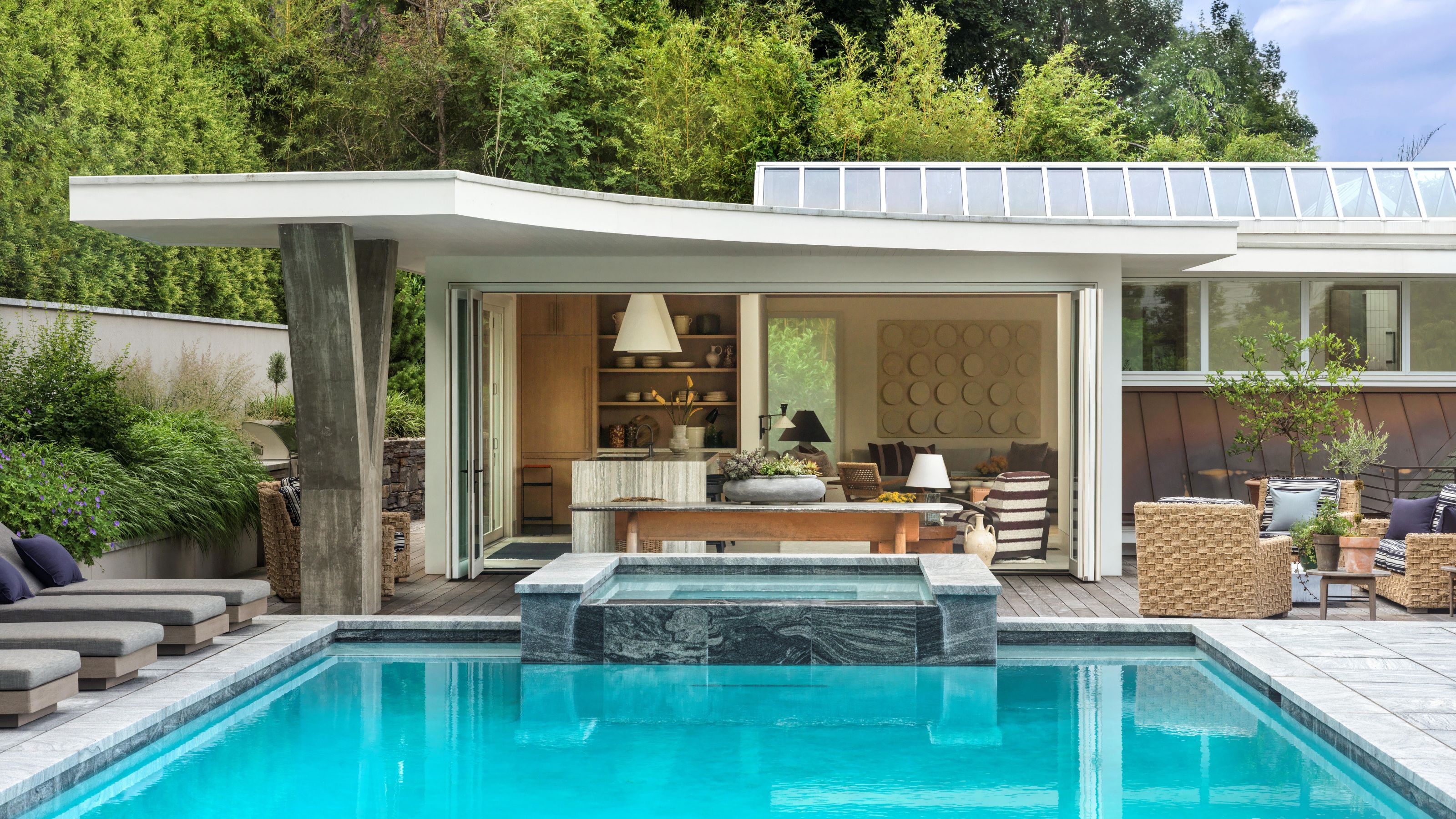 a brutalist low summer house beside a pool deck