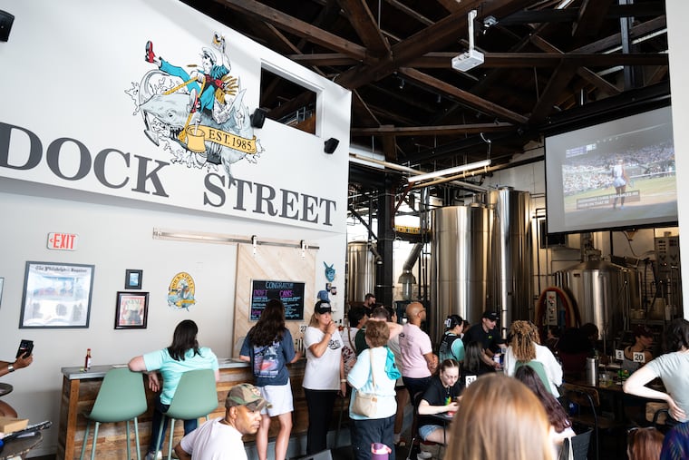 Fans watch a tennis match at Dock Street Brewery South during a watch party co-hosted by Hoopbus and The Stoop Pigeon on Saturday.