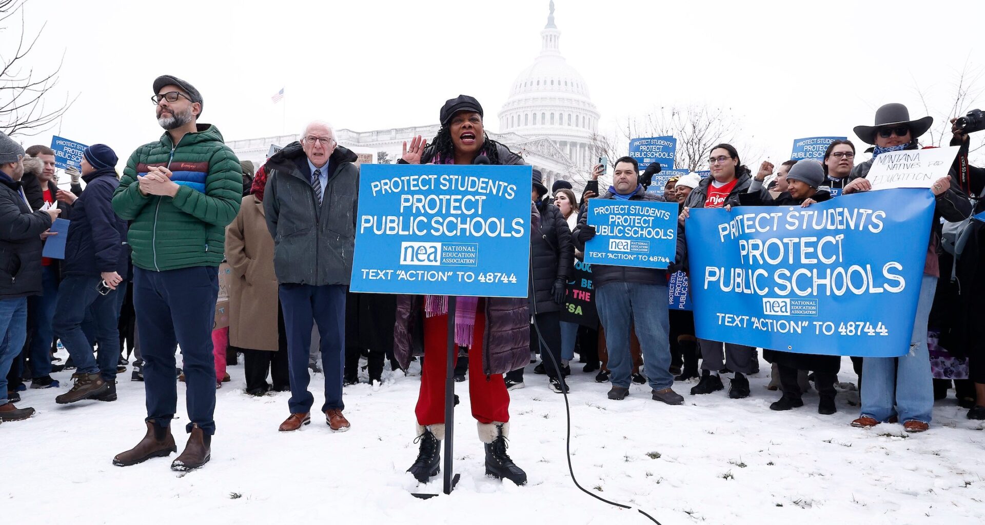 NEA leaders speakat a podium,