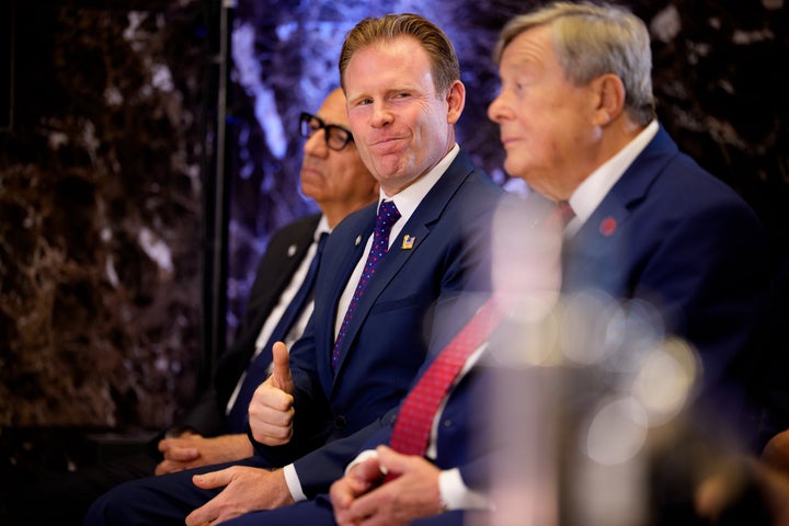 Andrew Giuliani (center) makes a thumbs up gesture while sitting alongside Viktor Knavs (right), father of first lady Melania Trump, as President Donald Trump speaks during a FIFA reception at Trump Tower on Friday in New York City. (Photo by Andrew Harnik/Getty Images)