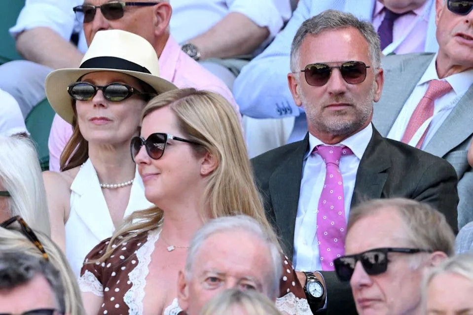 Christian Horner and Geri Halliwell sit among a crowd, both wearing sunglasses.